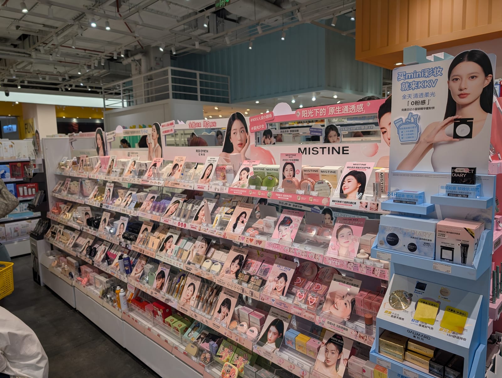 A color cosmetics aisle with rows of domestic Chinese makeup brands and shelf displays