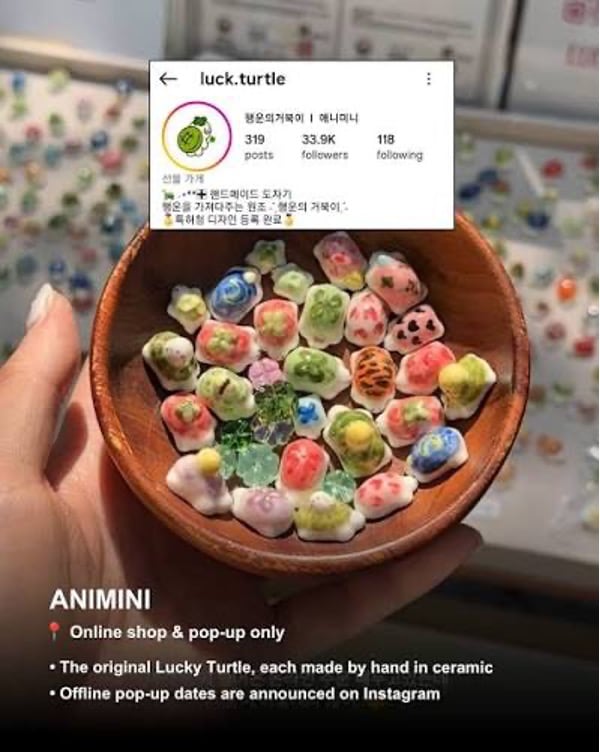 A hand holding a small wooden bowl of colorful handmade ceramic lucky-turtle charms, with an Instagram profile overlay